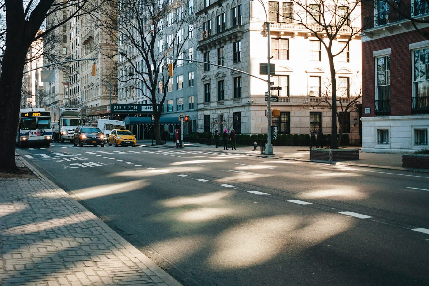 Illustrative diagram of object-detection annotation: a street scene with dashed boxes drawn around a bus, a taxi, and a group of pedestrians, each labeled with a confidence score.